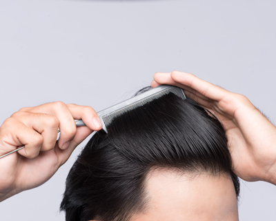 person styling hair with comb in hands