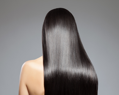 long shiny black hair seen from behind showcasing healthy glossy strands and reflecting light