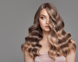 young woman with wavy shiny hair showcasing glamorous hairstyle and fashion beauty tips