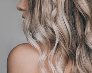 close up of wavy blonde hair with highlights showcasing healthy hair texture and style